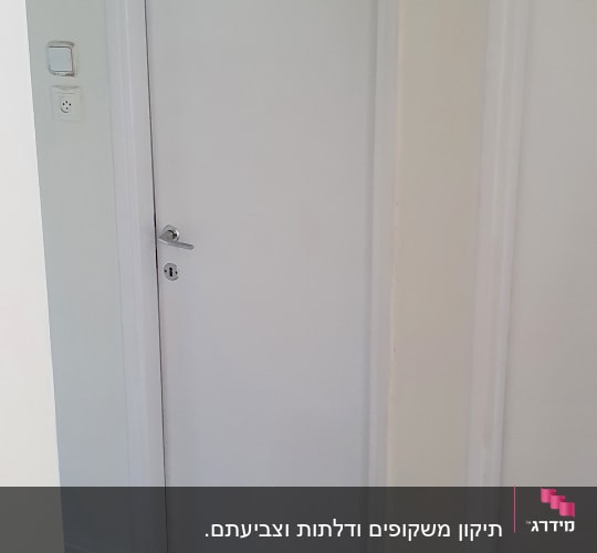 דלת לבנה עם חלון זכוכית על רצפת עץ